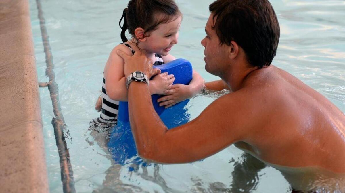 Aubrey Hage holds her kickboard with the help of swim instructor, Tim Fiscus, in July 2014 at Sonoma Elementary School’s Burris Pool in Modesto. Sacramento can reduce toddler drownings by expanding free, drop-in swim lessons at public pools to ensure every child learns lifesaving water safety skills.